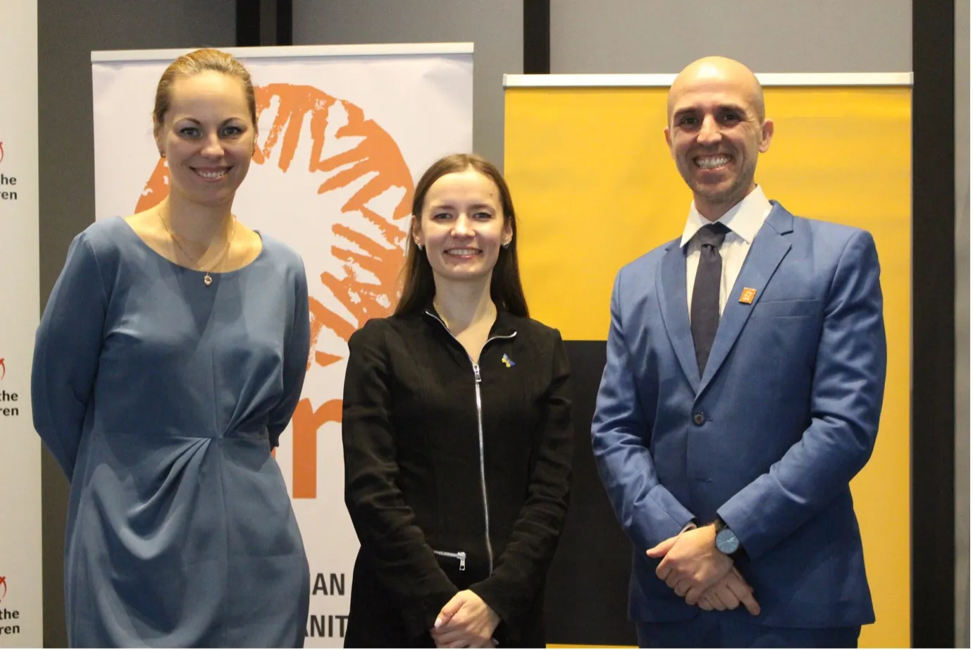 Portrait of three people, two women and a man, with a CARE banner behind them.